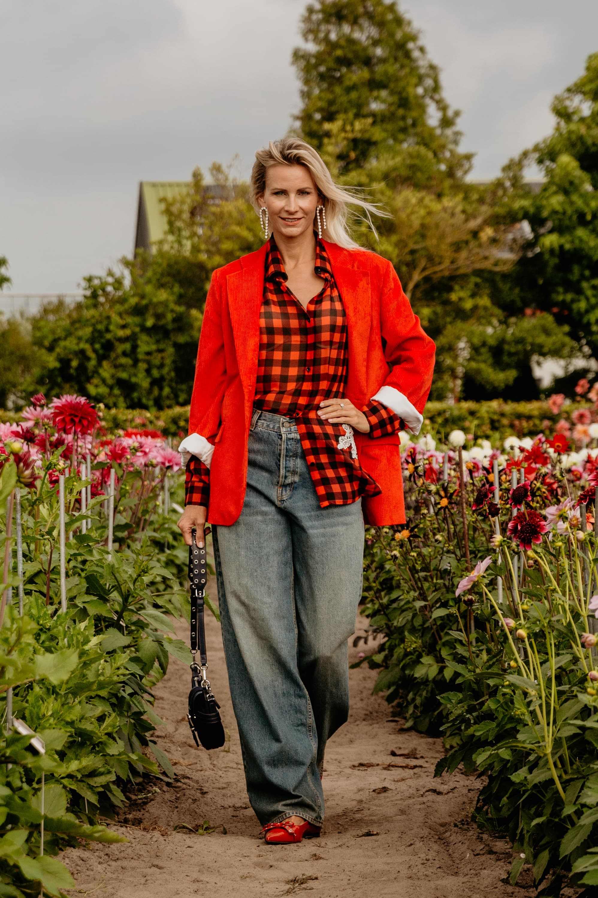 Suzanne in een rood-zwart geblokte blouse met blazer — een sterke fashion- en modeluitstraling