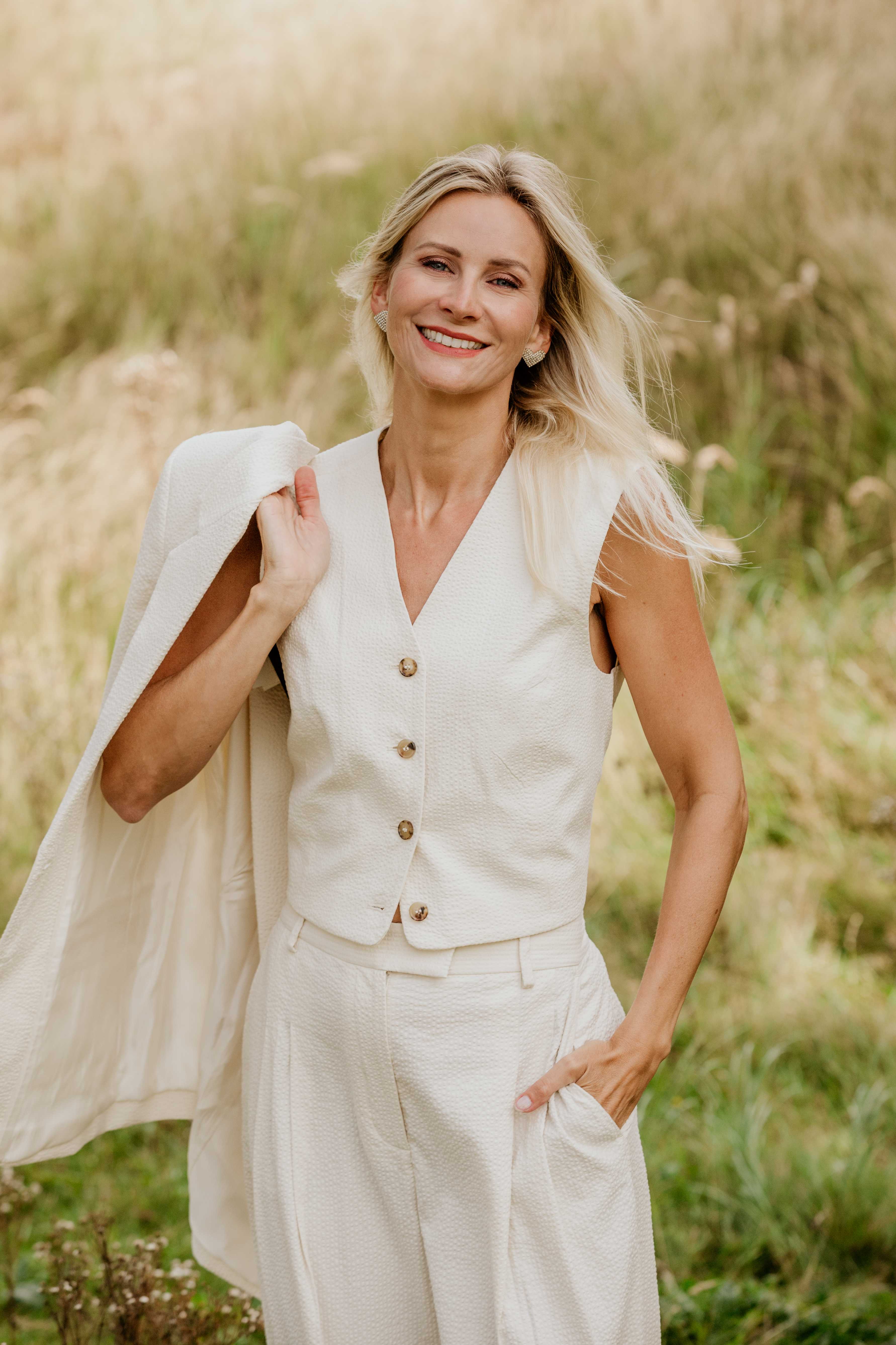 Suzanne Jongerius rechtop en elegant in een licht pak — houding, uitstraling en presence
