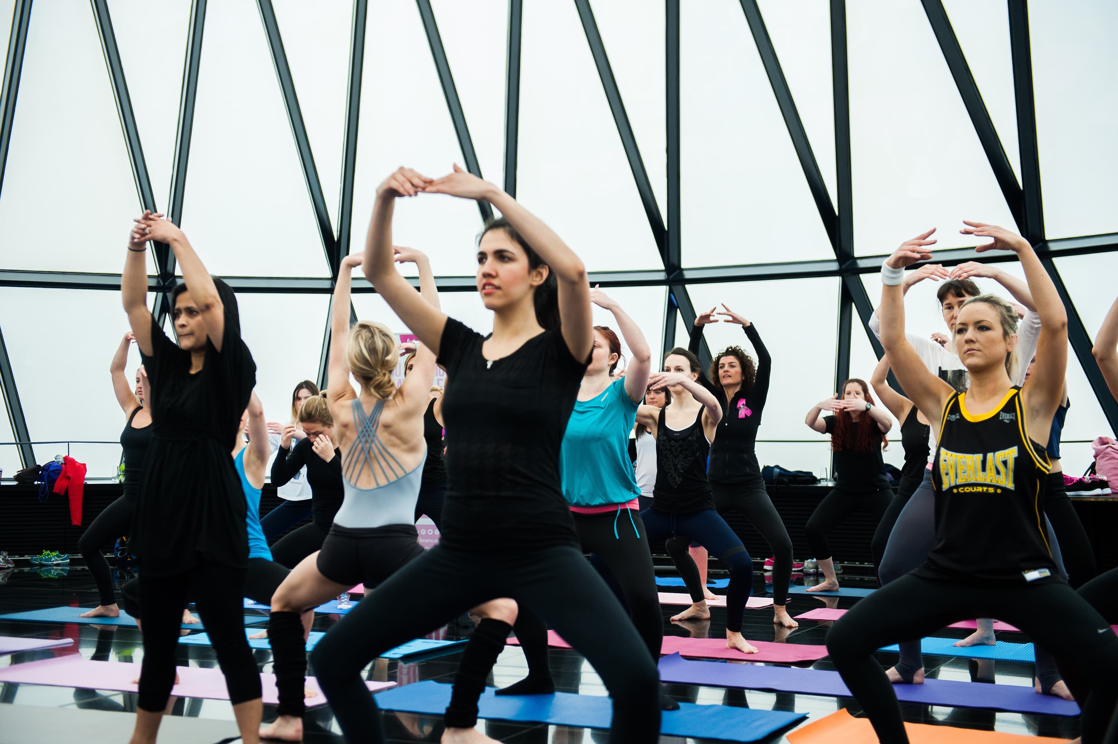Een groep volwassenen traint samen met sierlijke, gestrekte armen tijdens Sleek Technique® Ballet Fitness